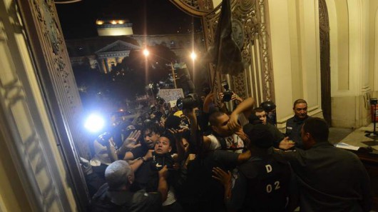 Policemen clash with anti-government demonstrators as they try to occupy the Rio de Janeiro's Municipal Chamber