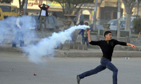 демонстрант бросает гранату с газом обратно в полицейских