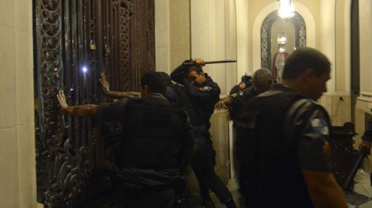 Policemen clash with anti-government demonstrators as they try to occupy the Rio de Janeiro's Municipal Chamber